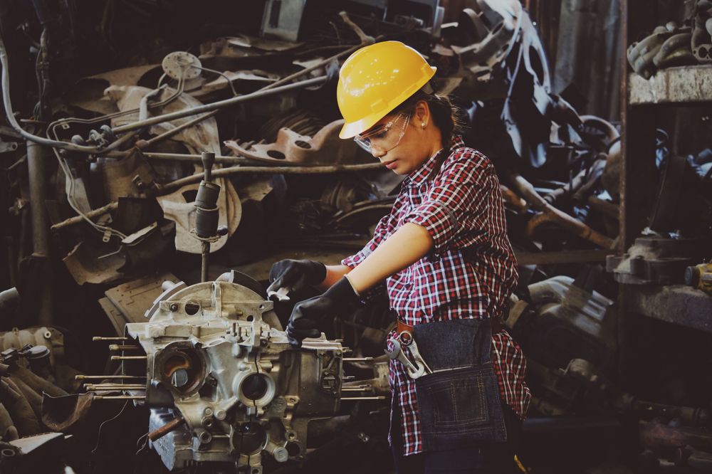 Operaria con equipo de protección trabajando en un taller industrial