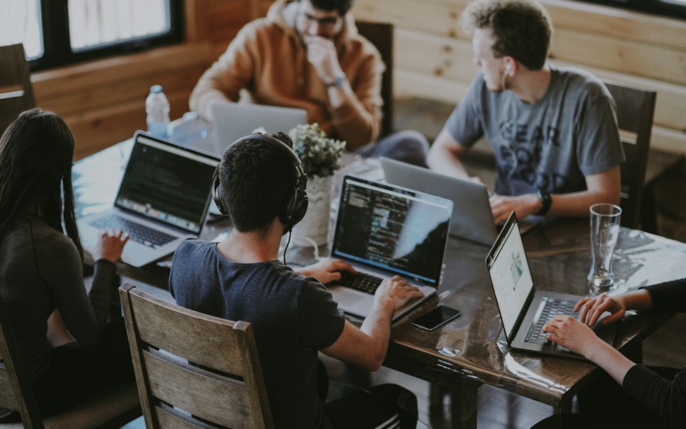 Equipo colaborando en proyectos con computadoras portátiles